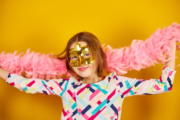 A joyful teenager girl wearing a colorful brazil carnival mask