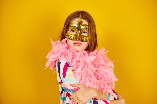 A joyful teenager girl wearing a colorful Brazil carnival mask