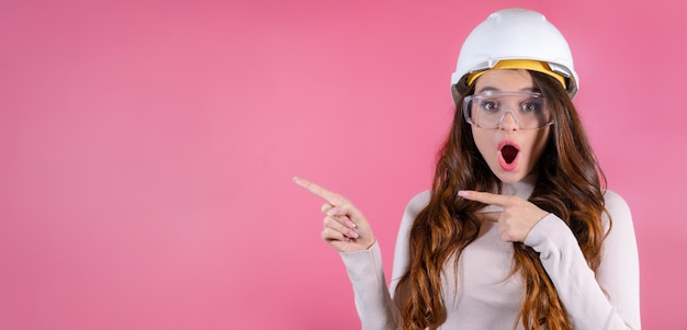 A joyful woman architect in helmet celebrating the successful completion of her project and shows on