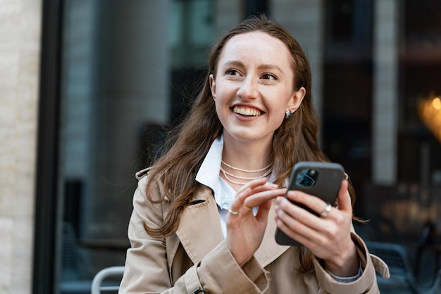 Joyful woman using smartphone outdoors embodying urban lifestyle and connectivity in the