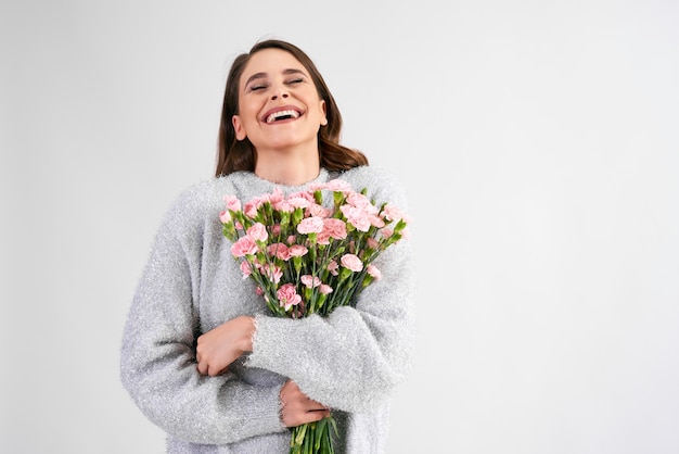 Donna allegra con un mazzo di chiodi di garofano rosa