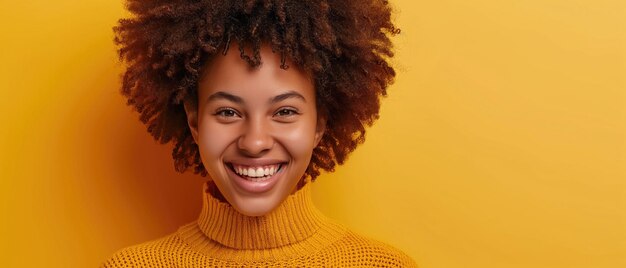 Foto donna gioiosa in maglione giallo capelli ricci che risplendono su uno sfondo giallo