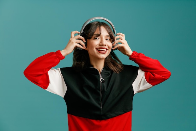 Joyful young caucasian woman looking at camera wearing headphones on isolated on blue background