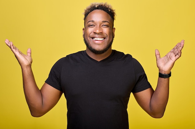 Joyful young guy of pleasant appearance spread his hands gratefully to sides