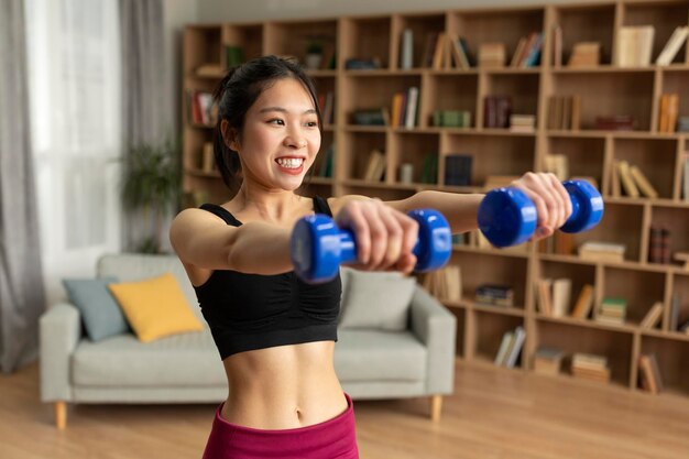 Photo joyful young japanese lady doing domestic training working out with dumbbells at home copy space