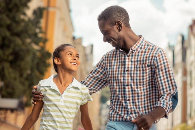 Joyful young man embracing his cute daughter