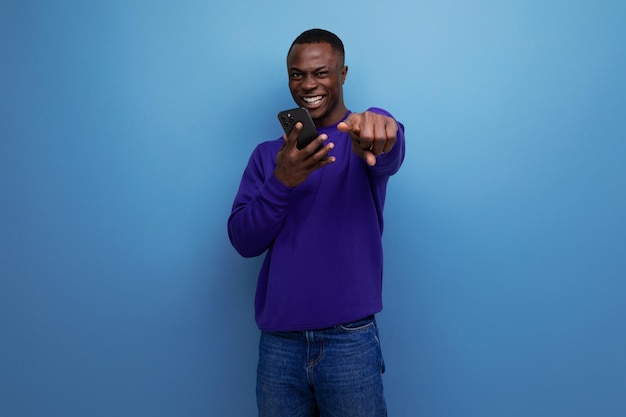 Joyful young man living in america looks at the smartphone screen