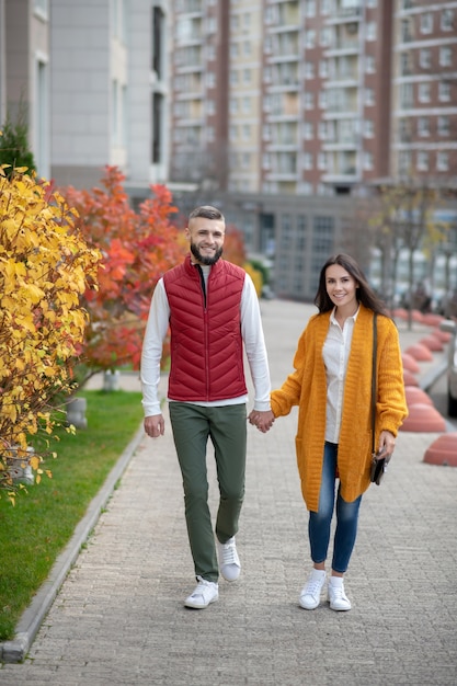 Joyful young people looking in front of them while having a romantic walk