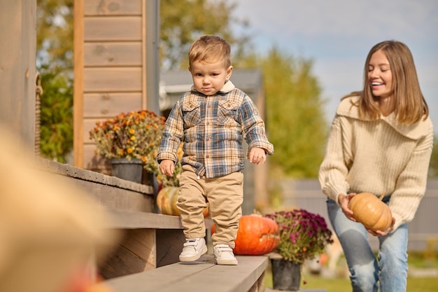 Joyful young woman and her child standing outdoors