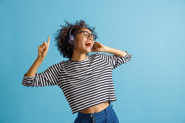 Joyful young woman listening to music through wireless headphones