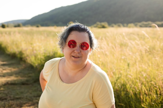 The joyful young woman in sunglasses pleasure nature