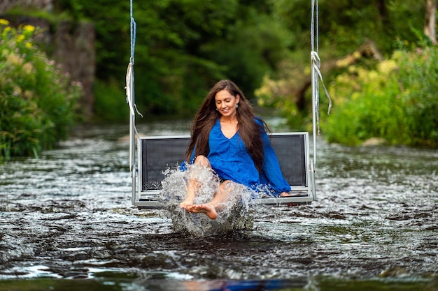 Premium Photo  A joyful young woman swings on a rope swing across