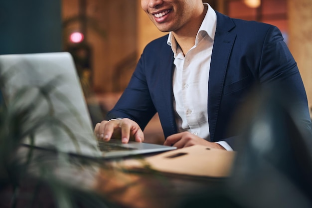 Telelavoratore maschio gioioso che lavora al suo computer