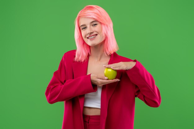 Joyous young woman demonstrating her favorite fruit before the camera