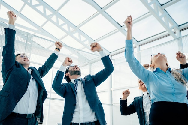 Jubilant business woman standing in front of her colleagues