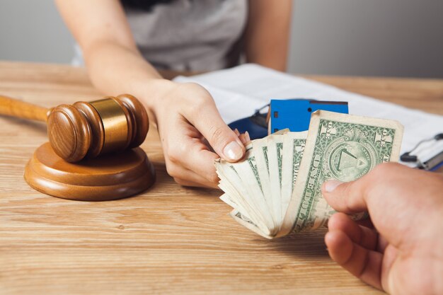 The judge accepts a bribe while sitting in front of the hammer