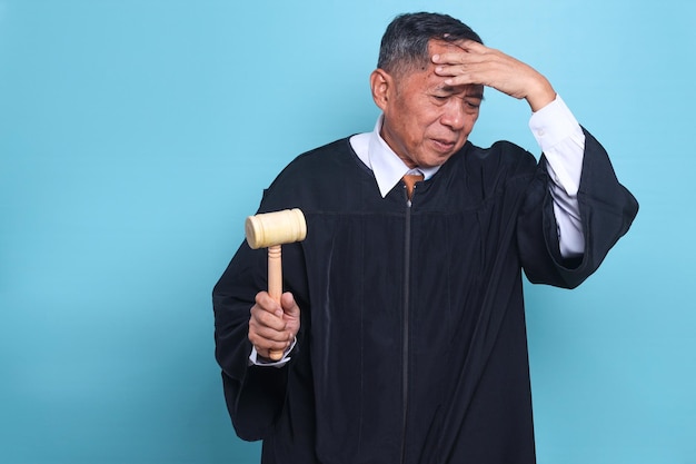 Judge Asian man with tired and sick expression isolated on blue background