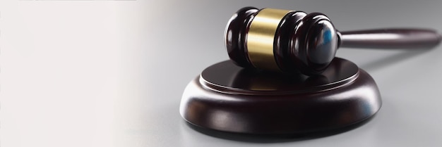 Судья черный деревянный молоток на деке на сером фоне адвокатский инструмент для юридических услуг