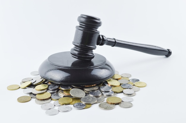 Judge gavel and coins over white background