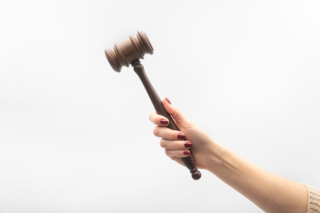 Judge gavel in female hand on white background. Woman judge concept.