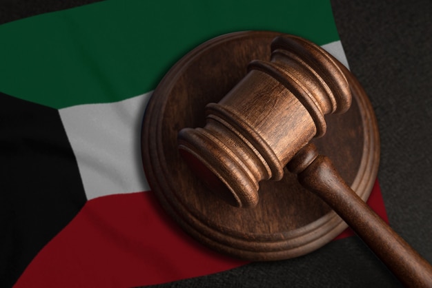Судейский молоток и флаг Кувейта. Закон и справедливость в Кувейте. Нарушение прав и свобод.