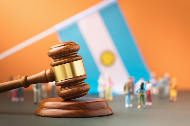 Judge gavel flag and plastic toy men the concept of a trial in Argentine society