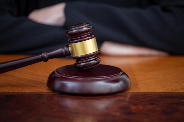 Judge gavel on law court desk blur female crossed hands close up view