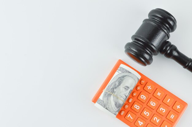 Photo judge gavel money banknote and calculator over white background written with compliance