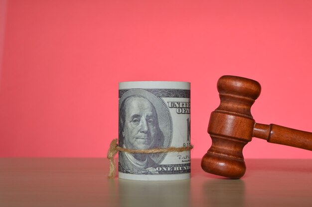 Judge gavel and money banknotes isolated on a red background