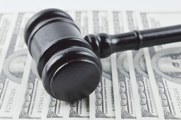 Judge gavel and money banknotes over white background