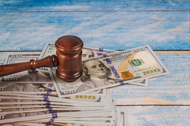 Photo judge gavel and money on blue wooden table.