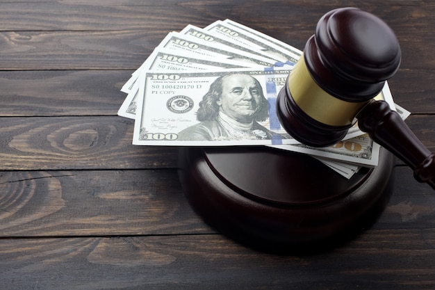 Judge gavel and money on brown wooden table concept