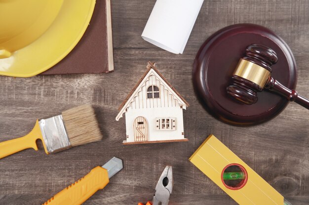 Judge gavel, safety helmet, house and working tools. Construction Law