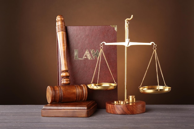 Judge gavel scales and book on wooden table