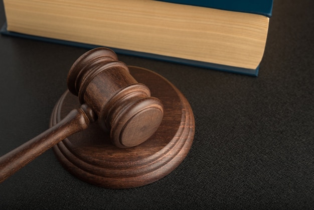 Judge gavel and sounding block and book in the background. Wooden hammer. Justice and law.