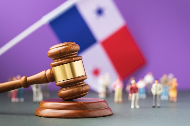 Judge gavel with blurred flag and plastic toy men background Panama society litigation concept