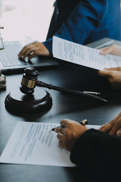 Il giudice gavel con gli avvocati della giustizia che hanno una riunione di squadra nello studio legale in background concetti di diritto