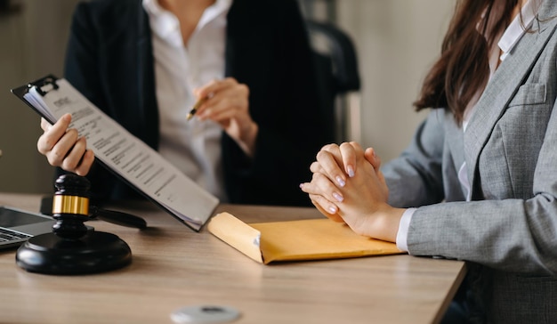 Judge gavel with scales of justice Business and lawyer or counselor consulting and discussing contract papers with laptop and tablet at law firm in office