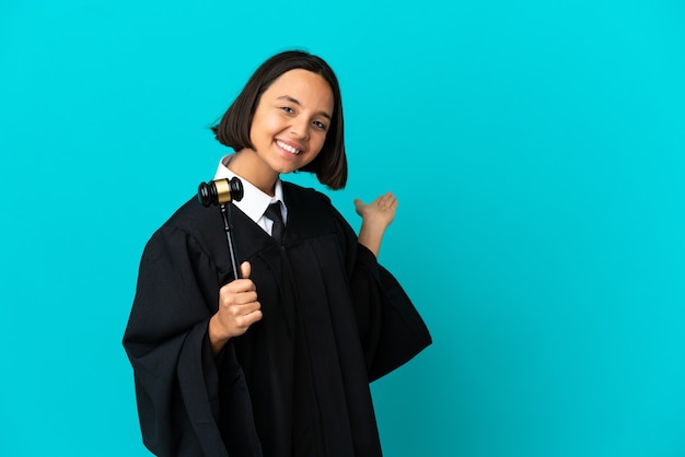 Judge over isolated blue background extending hands to the side for inviting to come