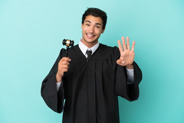고립 된 파란색 배경 위에 판사가 행복하고 손가락으로 4를 세다
