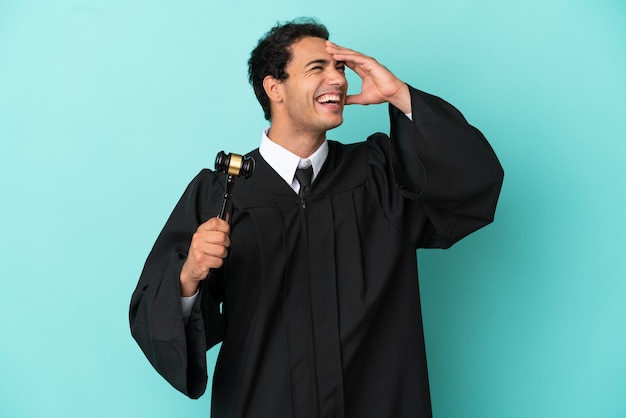 Judge over isolated blue background smiling a lot