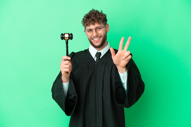 Judge over isolated green background happy and counting three with fingers