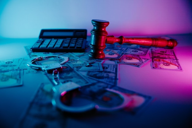 Judge's gavel and handcuffs with dollar banknotes Fraud concept