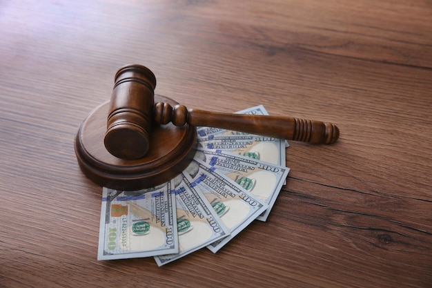 Judge's gavel and money on wooden table