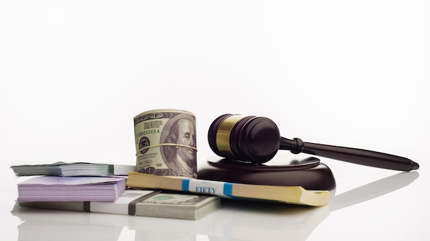 Judge's gavel and packs of dollars and euro banknotes on a white background
