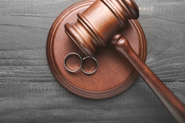 Judge's gavel and rings on wooden background. Concept of divorce