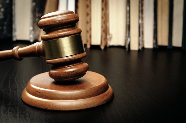 Judge's gavel on wooden table in dark