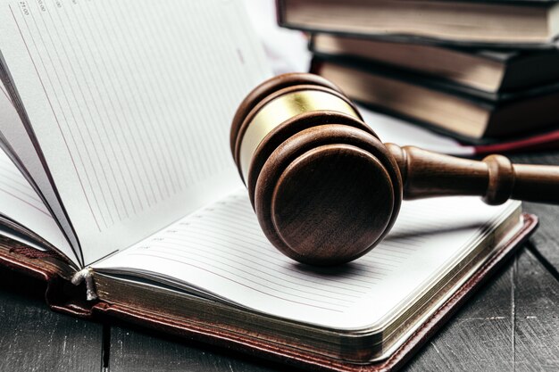 Judge's gavel on wooden table in dark