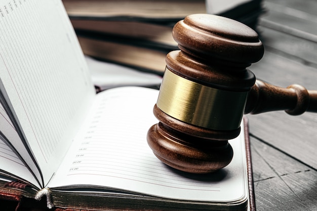 Judge's gavel on wooden table in dark