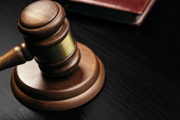 Judge's gavel on wooden table in dark